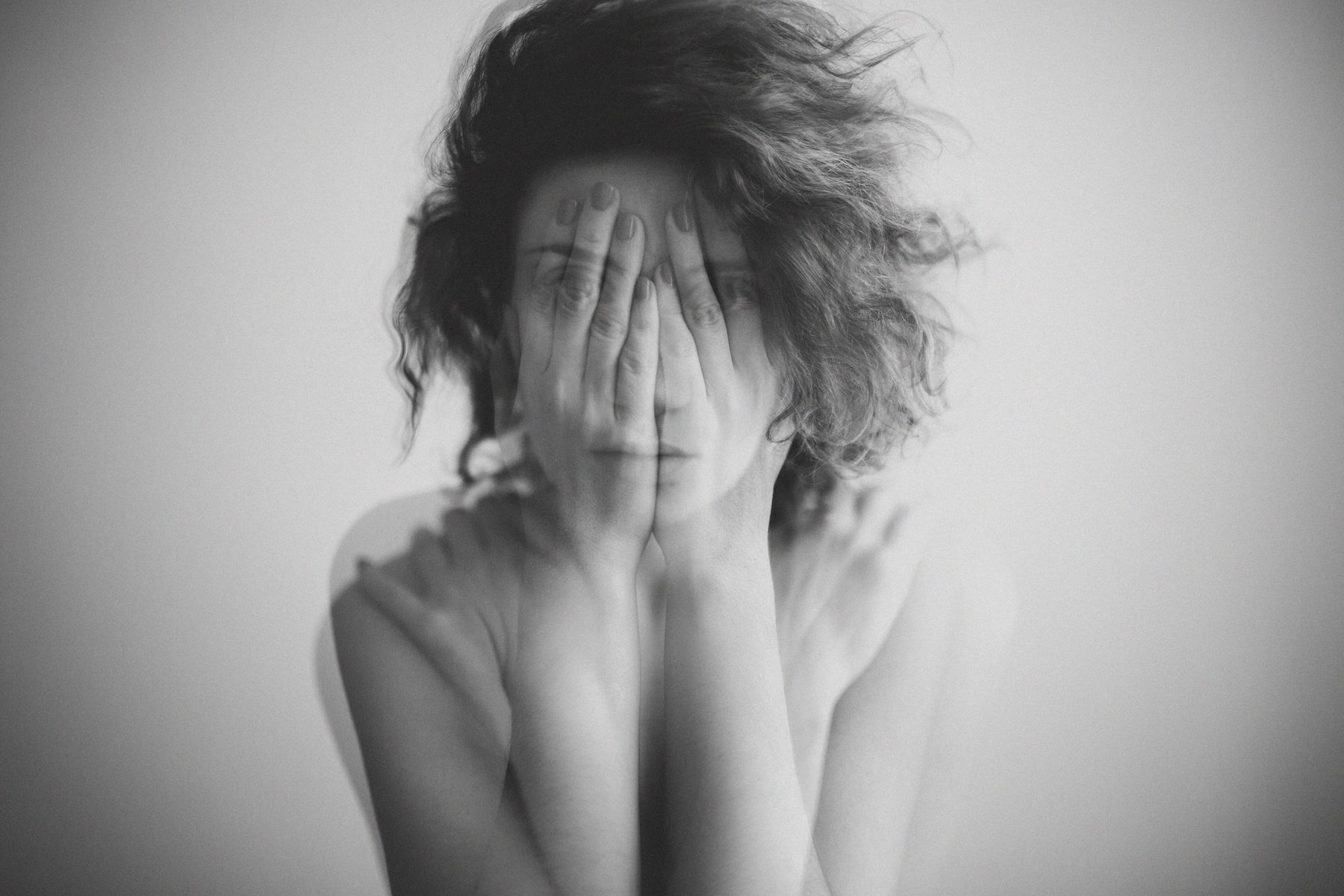 Hands partially covering face