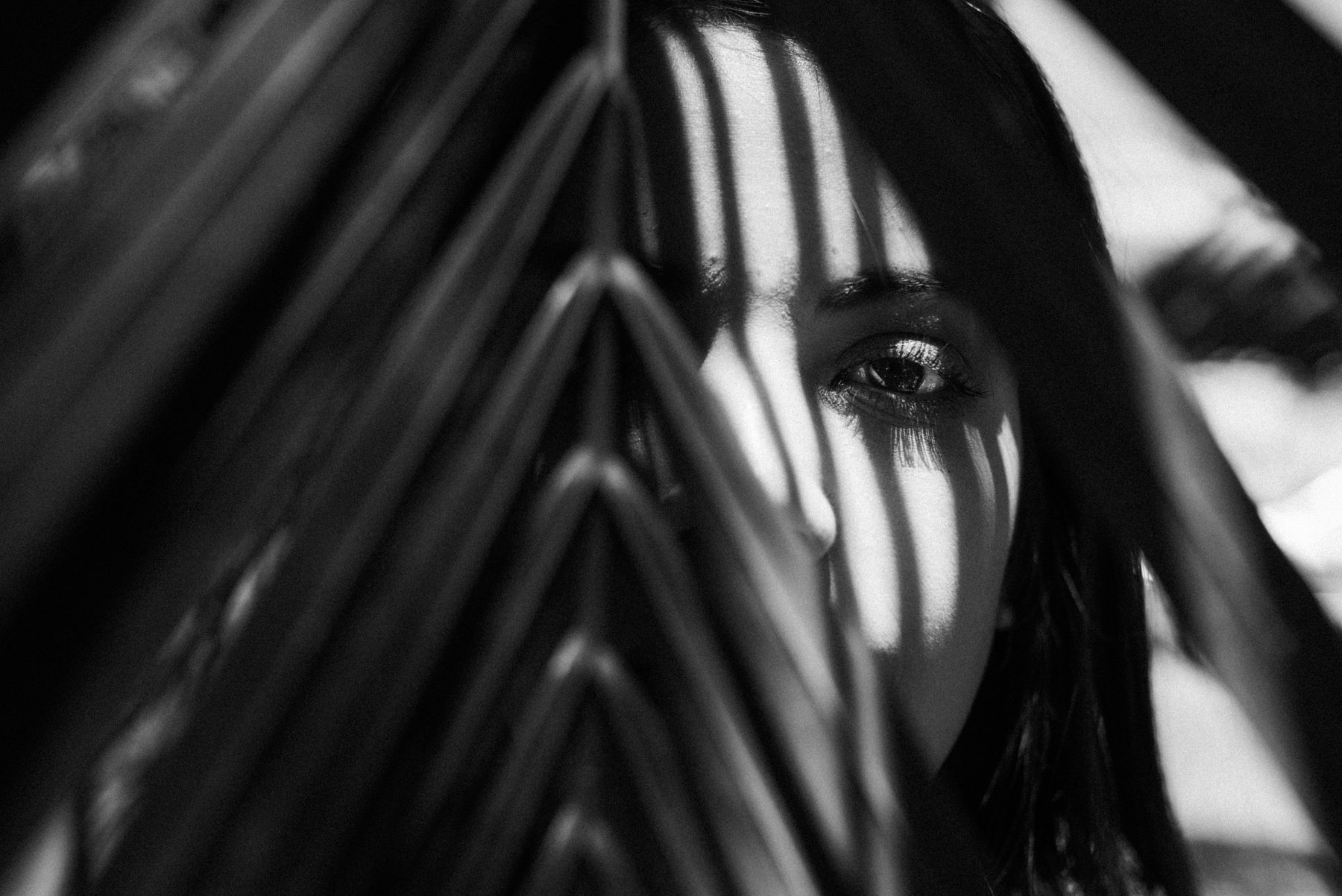 Black and white portrait partly hidden by leaves